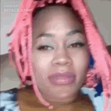 a woman with pink hair is making a funny face with reface app .