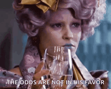 a woman in a purple wig is holding a glass of water and saying the odds are not in his favor .