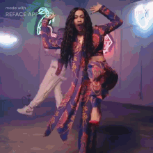 a woman in a colorful dress is dancing in front of a neon sign that reads reface app