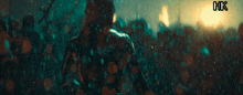 a man is standing in the rain with a xhk logo in the corner