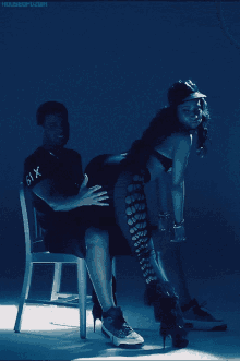 a man is sitting on a woman 's lap with the number 61x on his shirt
