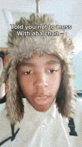 a young man wearing a furry hat with the caption told you not to mess with aba chan