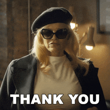 a woman wearing sunglasses and a black beret says " thank you "