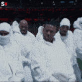 a blurred image of a group of people with the letters s on the bottom right