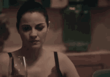 a woman in a bra is holding a wine glass