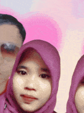 a woman wearing a purple hijab is standing next to a man