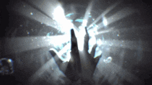 a person 's hand is reaching out towards a glowing light