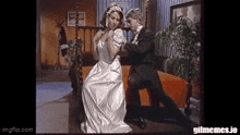 a man in a tuxedo and a woman in a wedding dress are dancing on a couch .