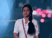 a woman in a white shirt is standing in front of a sign that says thiruda n chail