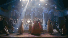 a group of women are dancing on a stage .