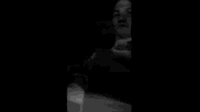 a black and white photo of a man in a white shirt kissing a woman .