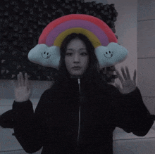a woman wearing a hat with a rainbow and two clouds on it