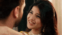 a man and woman are looking at each other and smiling .