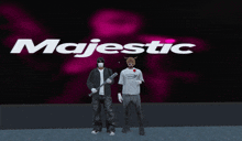 a couple of people standing in front of a majestic logo