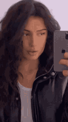 a woman taking a picture of herself in a mirror