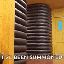 a room with a stack of tubes and the words `` i 've been summoned '' written on it .