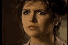 a close up of a woman 's face with a serious expression .