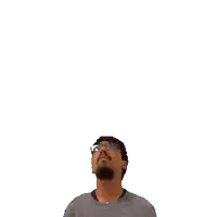 a man with glasses and a beard is looking up at a green cross on his head