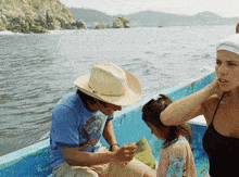 a man wearing a cowboy hat is sitting in a boat with a girl