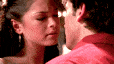 a man and a woman are kissing and the woman is wearing earrings