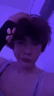 a person with short hair is taking a selfie in front of a purple light