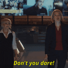 two women standing next to each other with the words " don 't you dare " in yellow letters