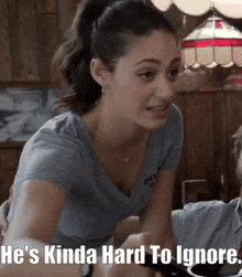 a woman says he 's kinda hard to ignore while sitting at a table