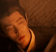 a close up of a man 's face with his eyes closed in a dark room