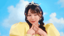 a girl in a yellow dress with a pearl tiara on her head
