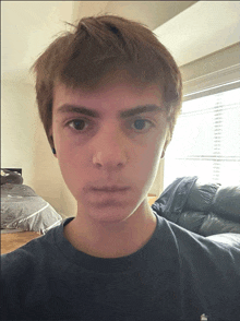 a young man wearing a black shirt with an apple logo on the sleeve