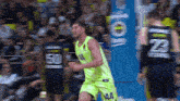 a basketball player in a neon green jersey with the number 44 on it