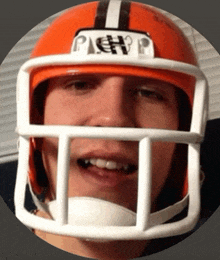 a man wearing an orange football helmet with the word packers on the front