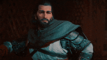 a man with a beard is wearing a blue cape and armor