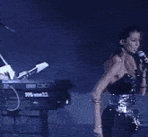 a woman singing into a microphone with a keyboard in the background that says r22