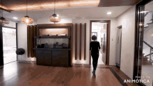 a woman walking in a room with the words made in animotica on the bottom right