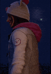a person wearing a hat and a jacket with a smiley face on the back