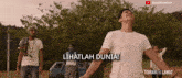 a group of people standing in a field with the words lihatlah dunia