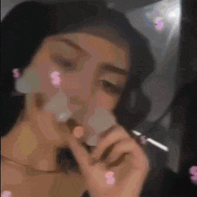 a woman is smoking a cigarette with smoke coming out of her mouth .