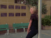 a woman leaning against a pole with a nbc logo on the bottom