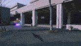 a blurred image of a building with a blue and purple glowing object in front of it