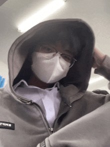 a person wearing a face mask and a hoodie that says eme