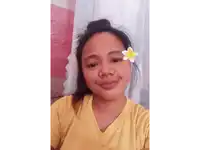 a woman with a flower in her hair looks at the camera