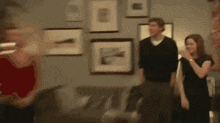 a blurry picture of a group of people standing in front of a wall with pictures on it