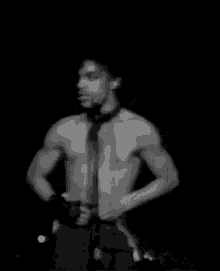 a shirtless man is singing into a microphone on a stage .