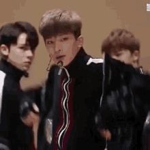 a group of young men are standing next to each other and one of them is wearing a microphone .