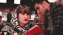 a man and a woman are talking to each other in a restaurant .