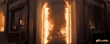 a building is on fire and smoke is coming out of the doorway .