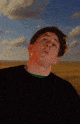 a man in a black shirt with a green shirt underneath is standing in a field with his mouth open