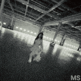 a black and white photo of a woman in a warehouse with the letters ms on the bottom right