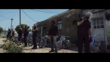 a group of men are standing in front of a building with motorcycles